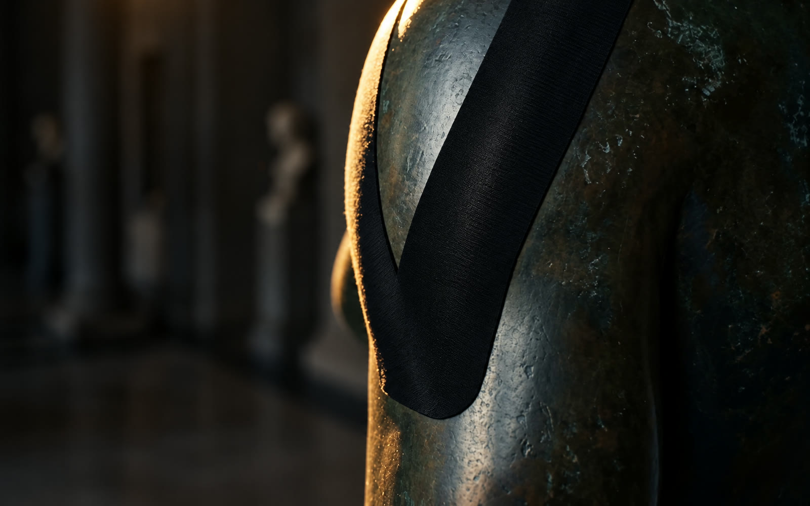 Nahaufnahme: schwarzes Kinesiologie-Tape mit feinem Rayon-Gewebe auf der Schulter einer Bronzeskulptur, im warmen Licht eines Museums.